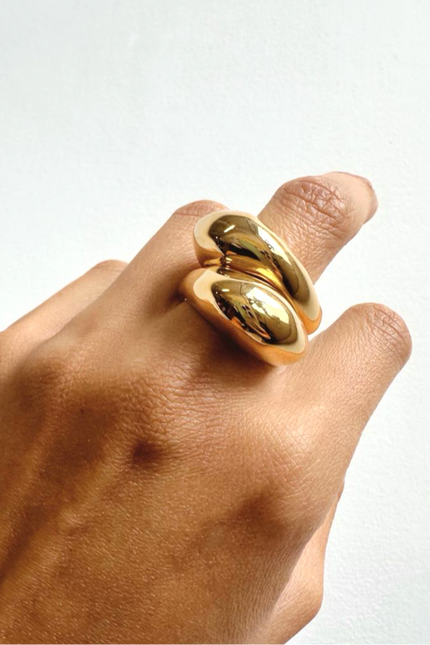 Gold ring on a finger against a white background