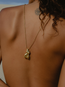 A person with curly hair, seen from behind, wears the Divine Feminine Necklace on an 18k gold-filled chain. An eye tattoo is visible near their upper back in a softly lit, neutral background.
